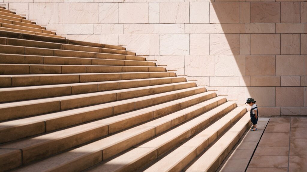 little boy looking at tall stairs